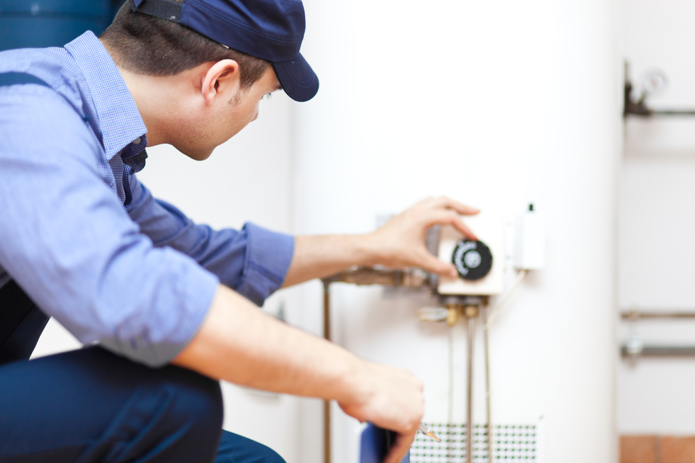 Beech Grove plumber adjusting traditional water heater